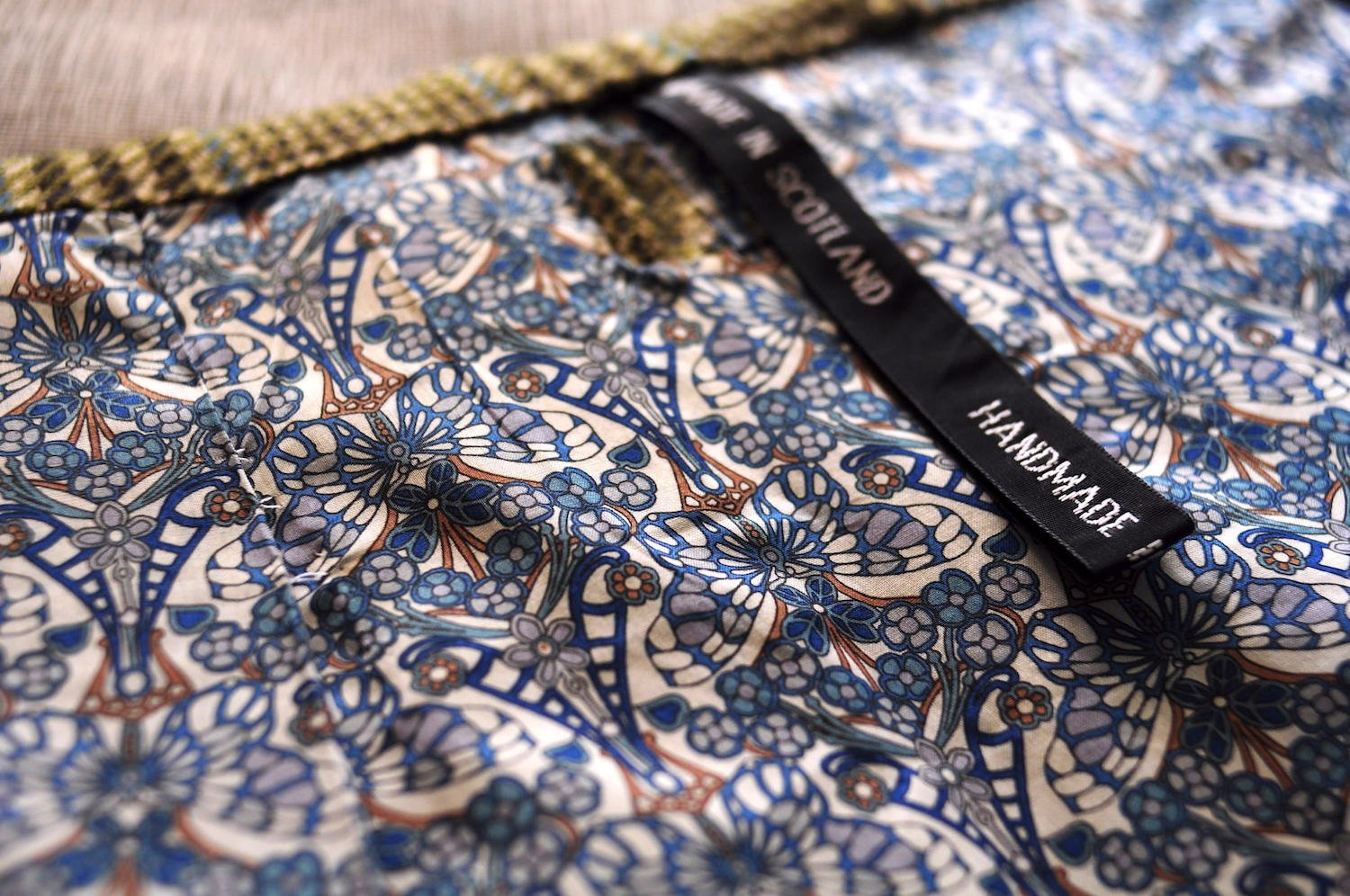 Close up image of blue and white butterfly print lining with a tag that says &
