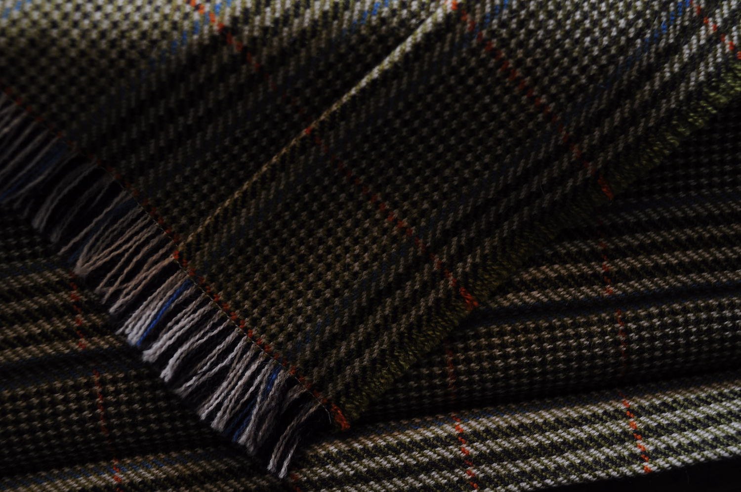 Close up image of plaid fabric with a fringed edge.