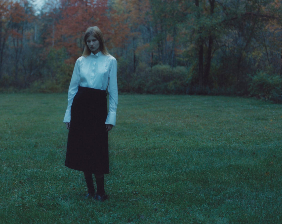 Image of a model wearing a kilt and white shirt standing in a foggy field of grass
