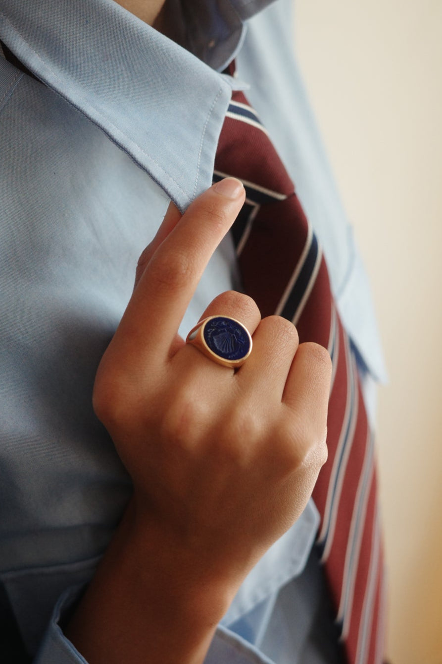 Person wearing a ring with a blue stone, blurred background