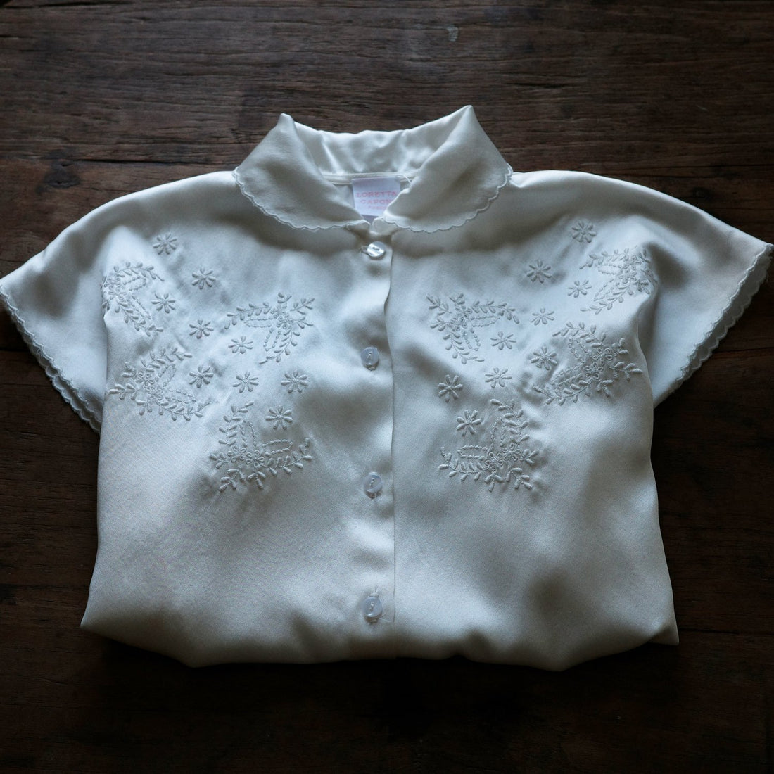 Folded Short sleeve collared shirt with floral embroidery.
