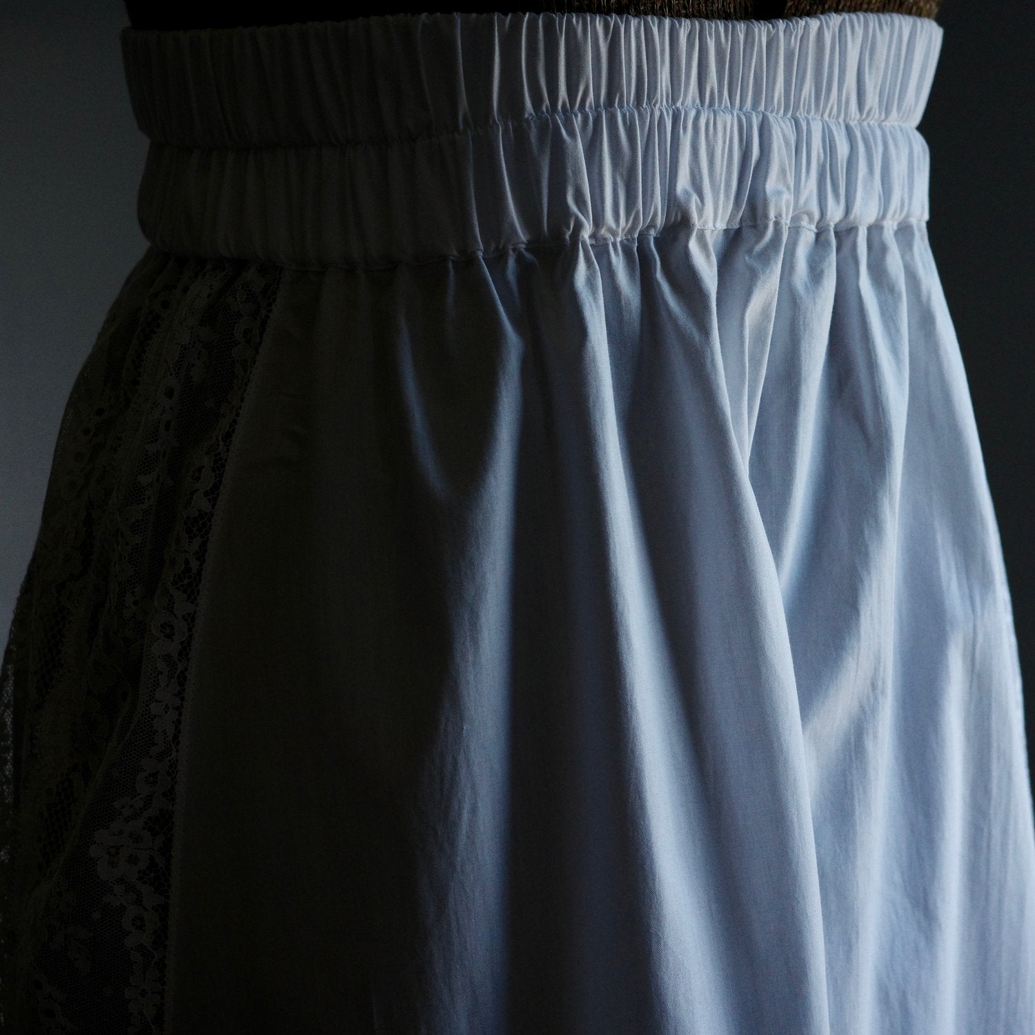 Detail shot of an elasticated waistband on a white skirt