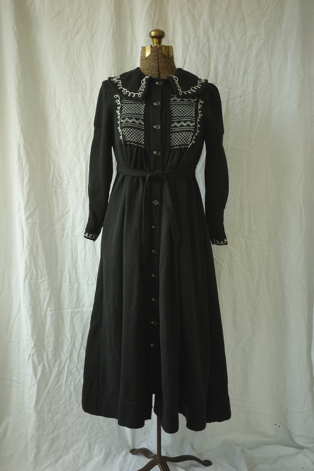 A black dress is displayed on a mannequin.