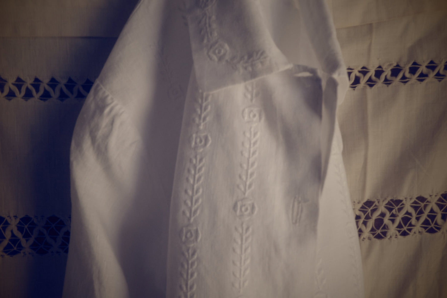 A white blouse folded on eyelet fabric.