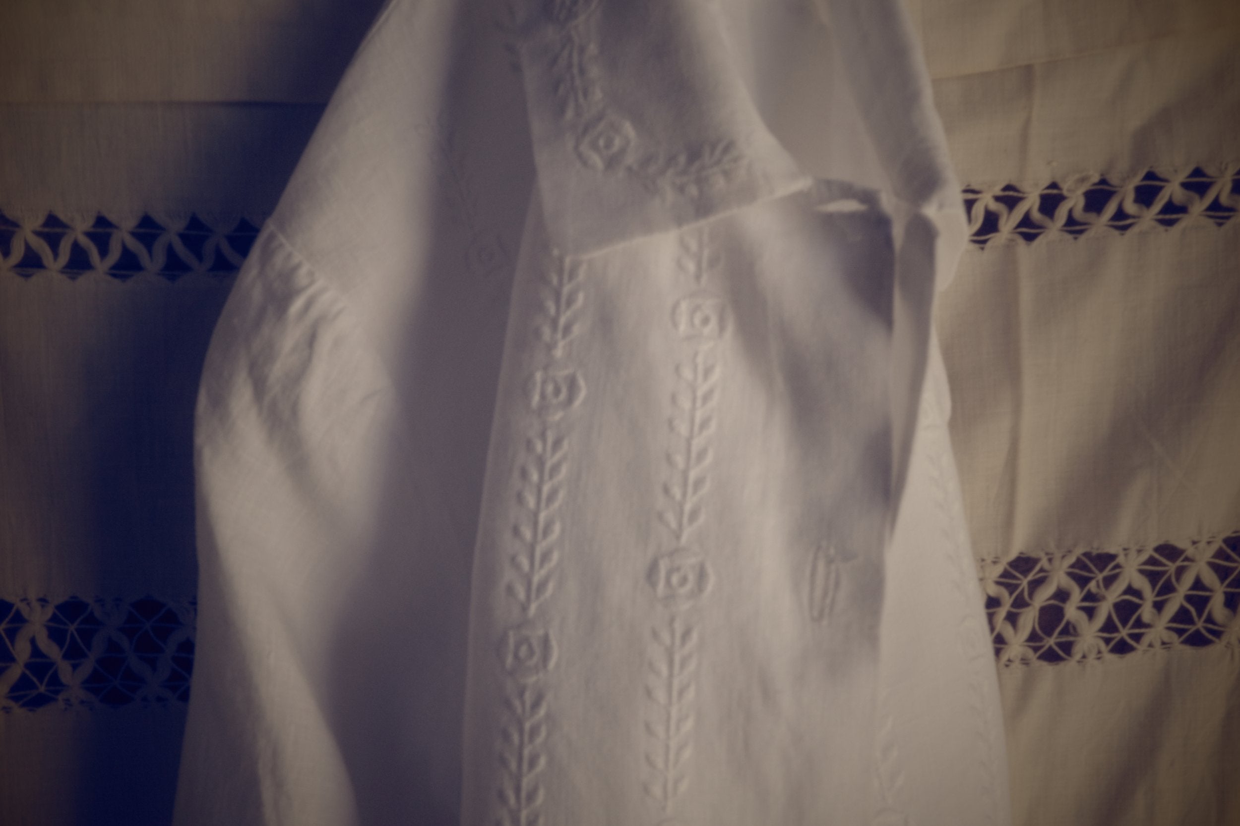 A white blouse folded on eyelet fabric.