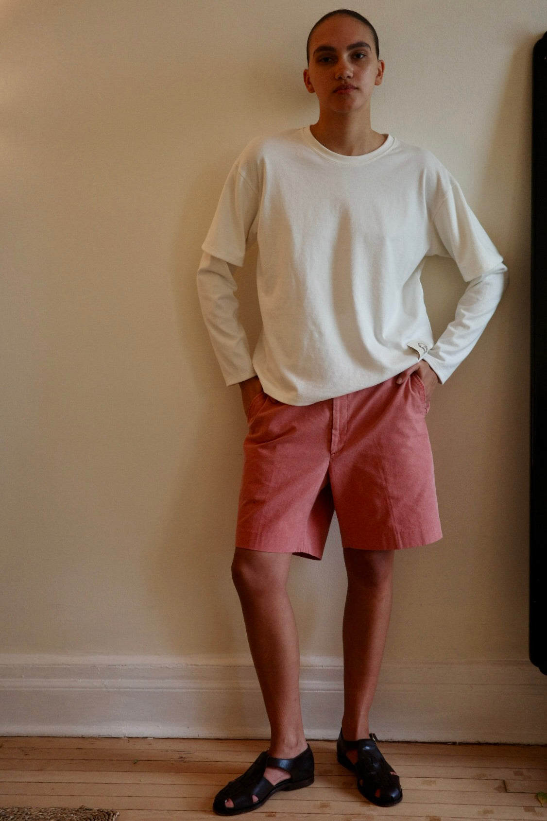 Woman standing in red shorts and white shirt