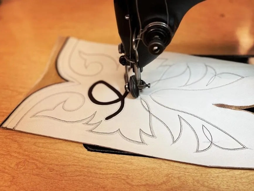 A close up image of an embroidery machine needle producing one of Holly Henry's cowboy boot designs.