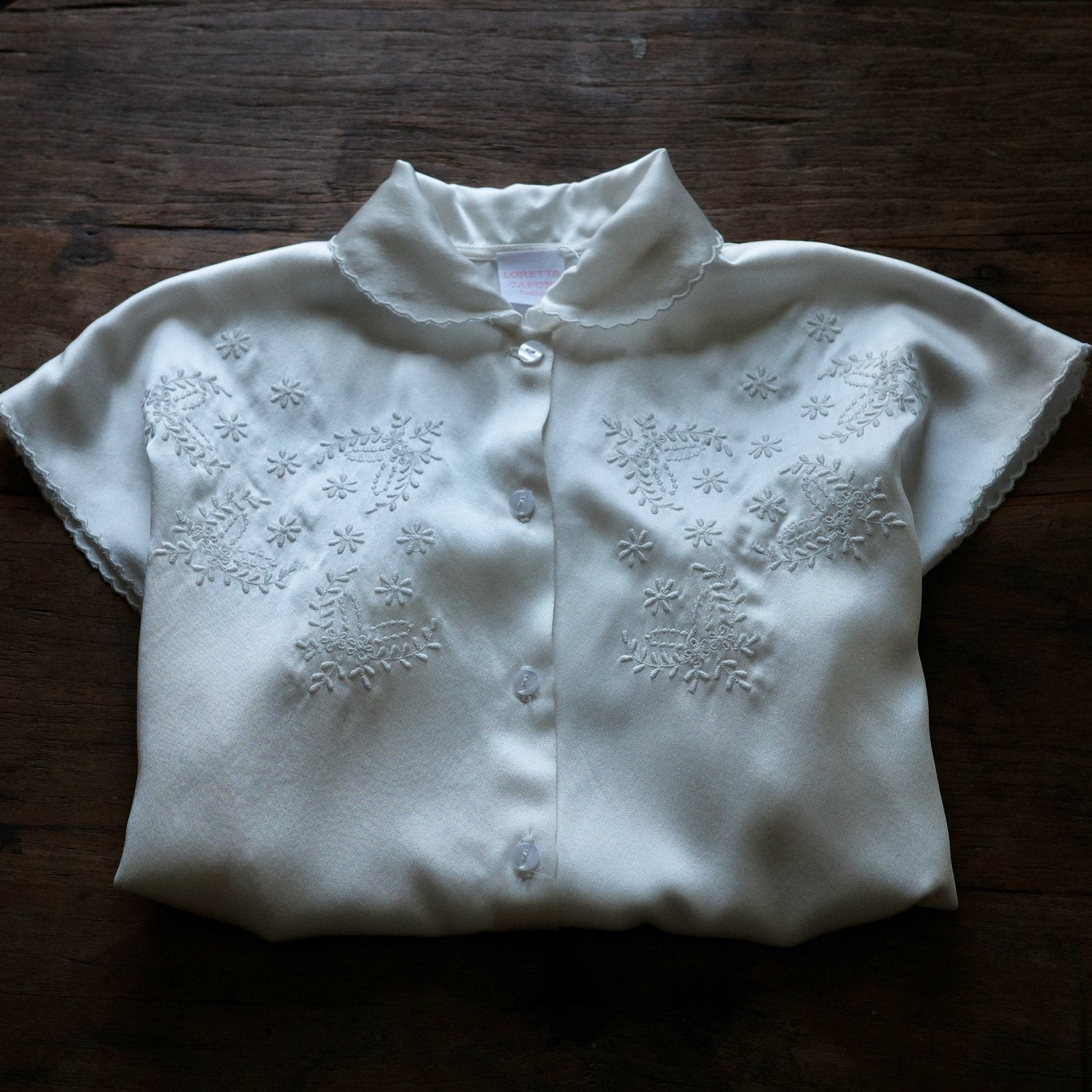 Folded Short sleeve collared shirt with floral embroidery.