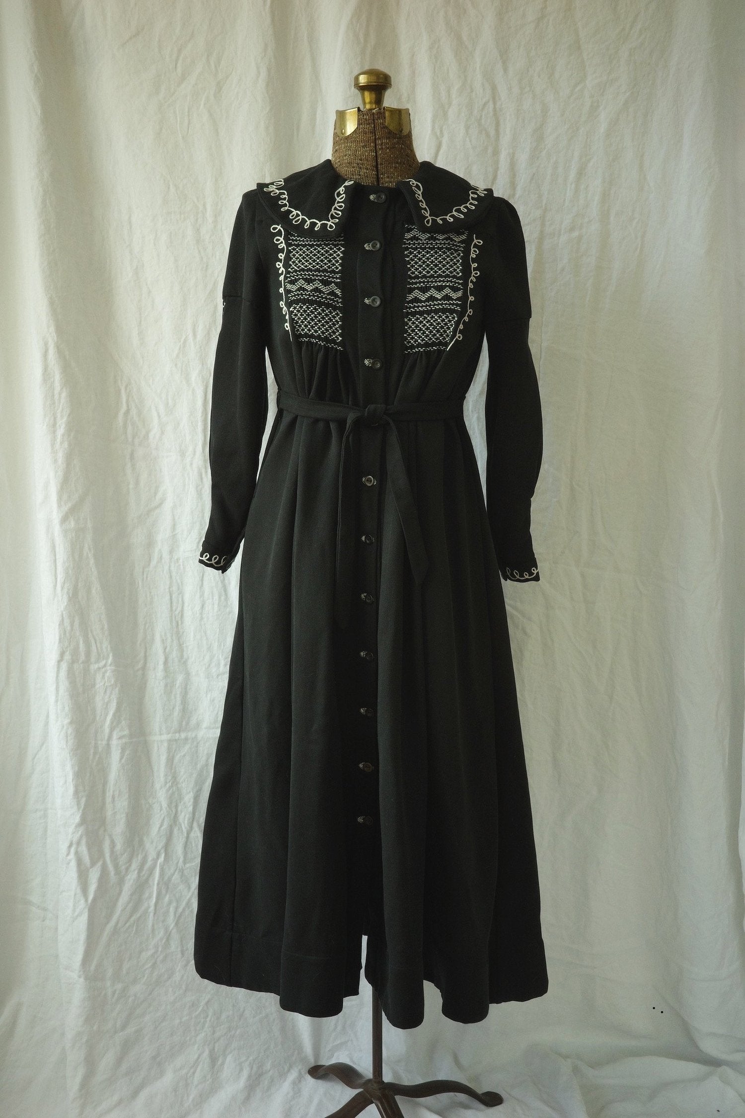 A black dress is displayed on a mannequin.