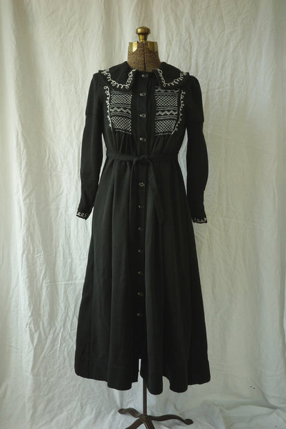 A black dress is displayed on a mannequin.