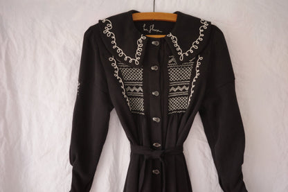 Close up image of the embroidery on a black dress.