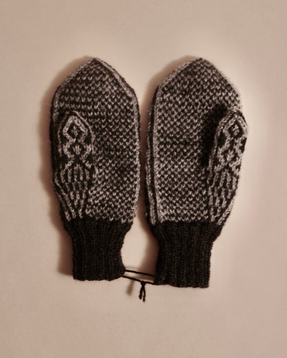 Pair of knitted mittens with a decorative pattern on a beige background