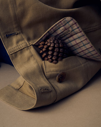 Close up image of a pocket lined in plaid fabric with a pinecone peeking out.