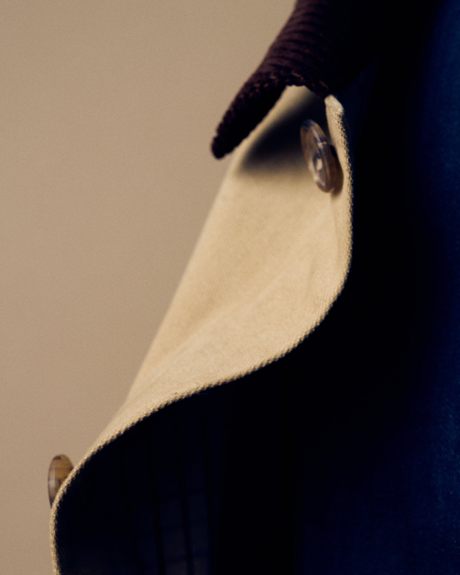 Close up image of buttons on a tan coat.
