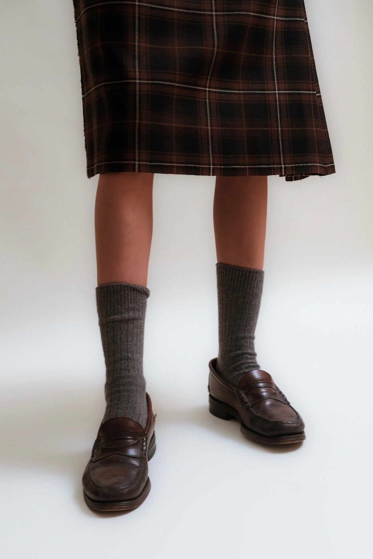 Hem detailing of a black and brown tartan kilt.
