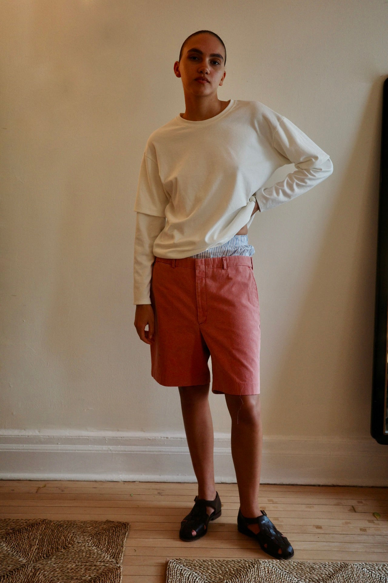 Woman standing with hand on hips wearing red shorts